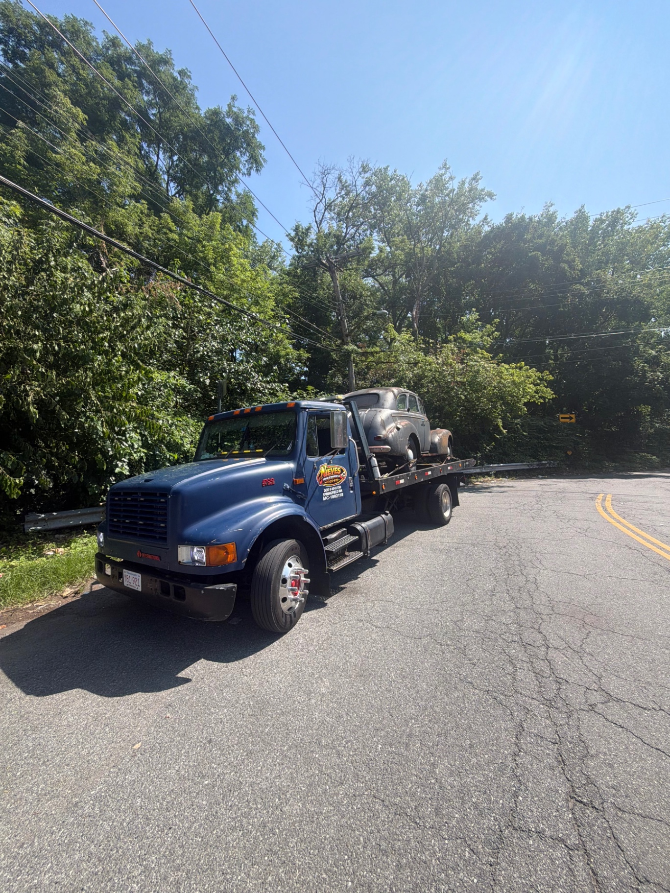 Nieves Towing flatbed hauling a vintage classic car in Western Massachusetts